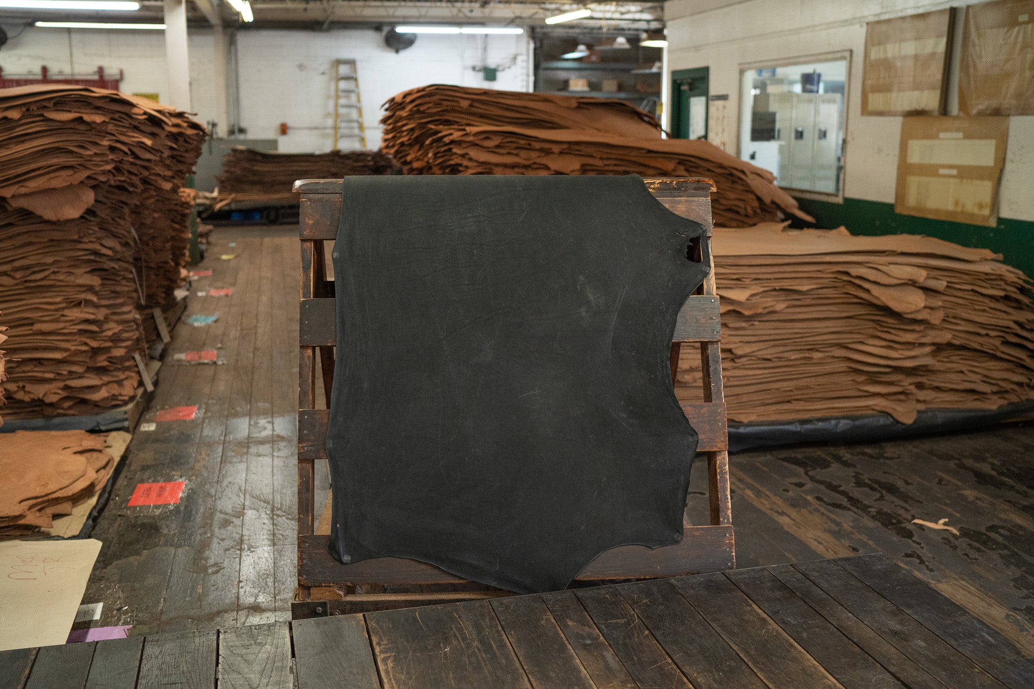 Black Expedition Leather from Hermann Oak Leather Co displayed on a wooden rack