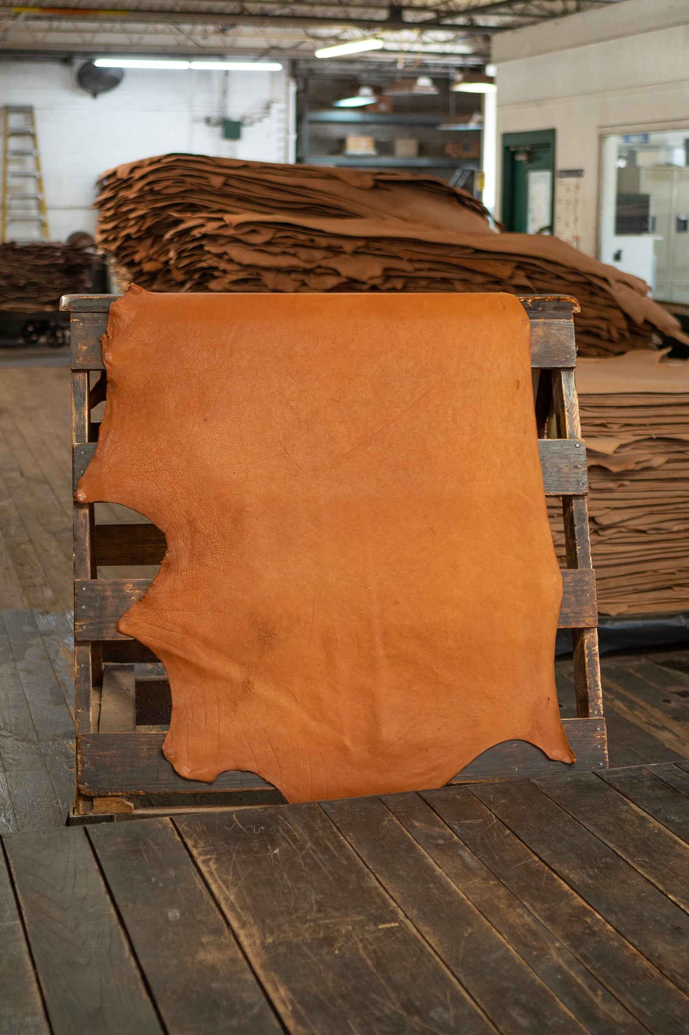 Chestnut Heritage Leather from Hermann Oak Leather Co displayed on a wooden rack